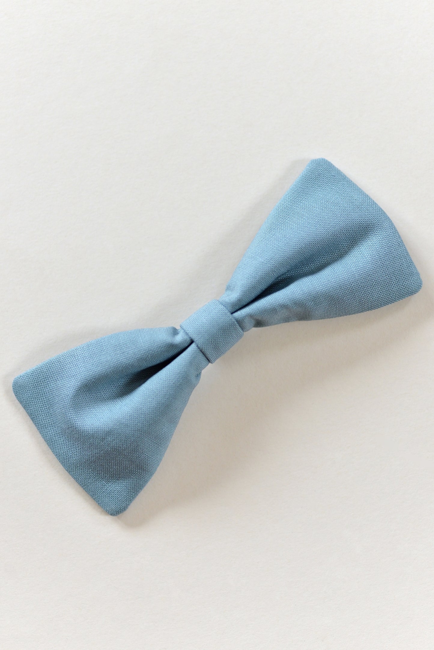 Handmade steel blue bow on a light background.