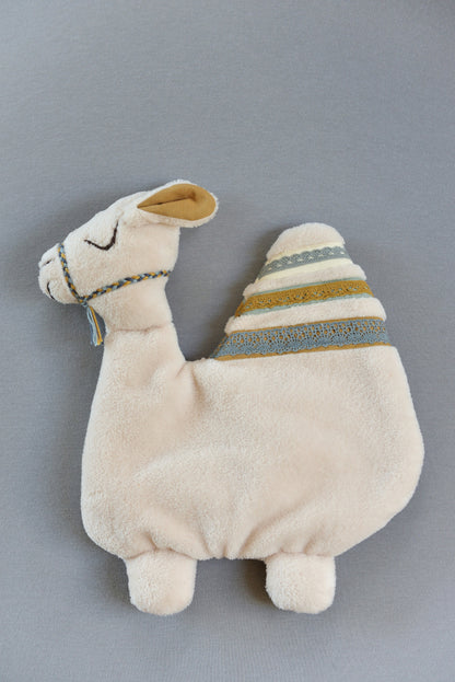 Handmade camel shaped baby comforter with ivory body and mustard, blue lace details on a blue background.