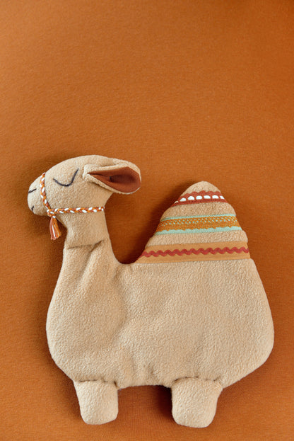 Handmade camel shaped baby comforter with tan body and green, terracotta and rust  lace details on a terracotta background.