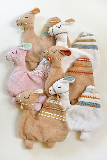 Selection of handmade camel shaped baby lovey with lace details on an ivory background in different colours: ivory, tan and blush pink.