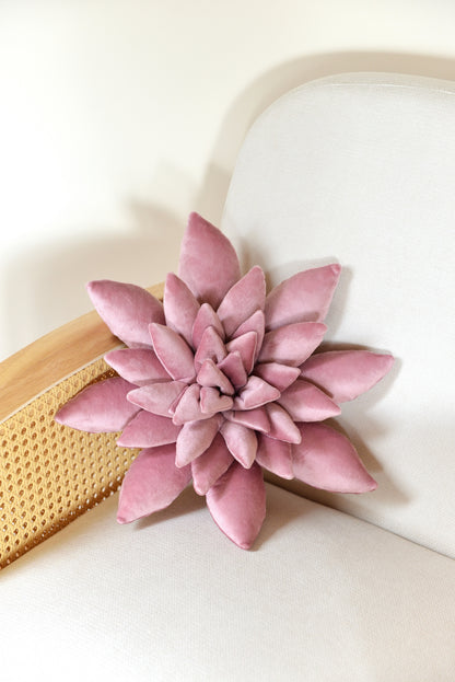 Standard size succulent shaped velvet decor pillow in lilac colour placed on an ivory rattan armchair.
