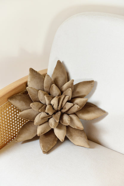 Standard size succulent shaped velvet decor pillow in sand colour placed on an ivory rattan armchair.